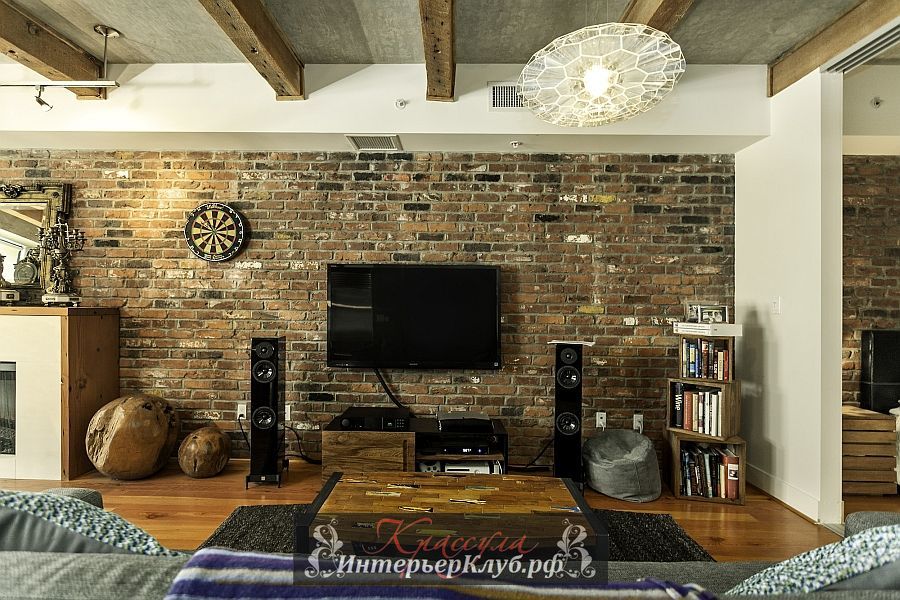 Кирпичная стена, цементный потолок, деревянные балки и стильный современный декор в интерьере красивой лофт квартиры