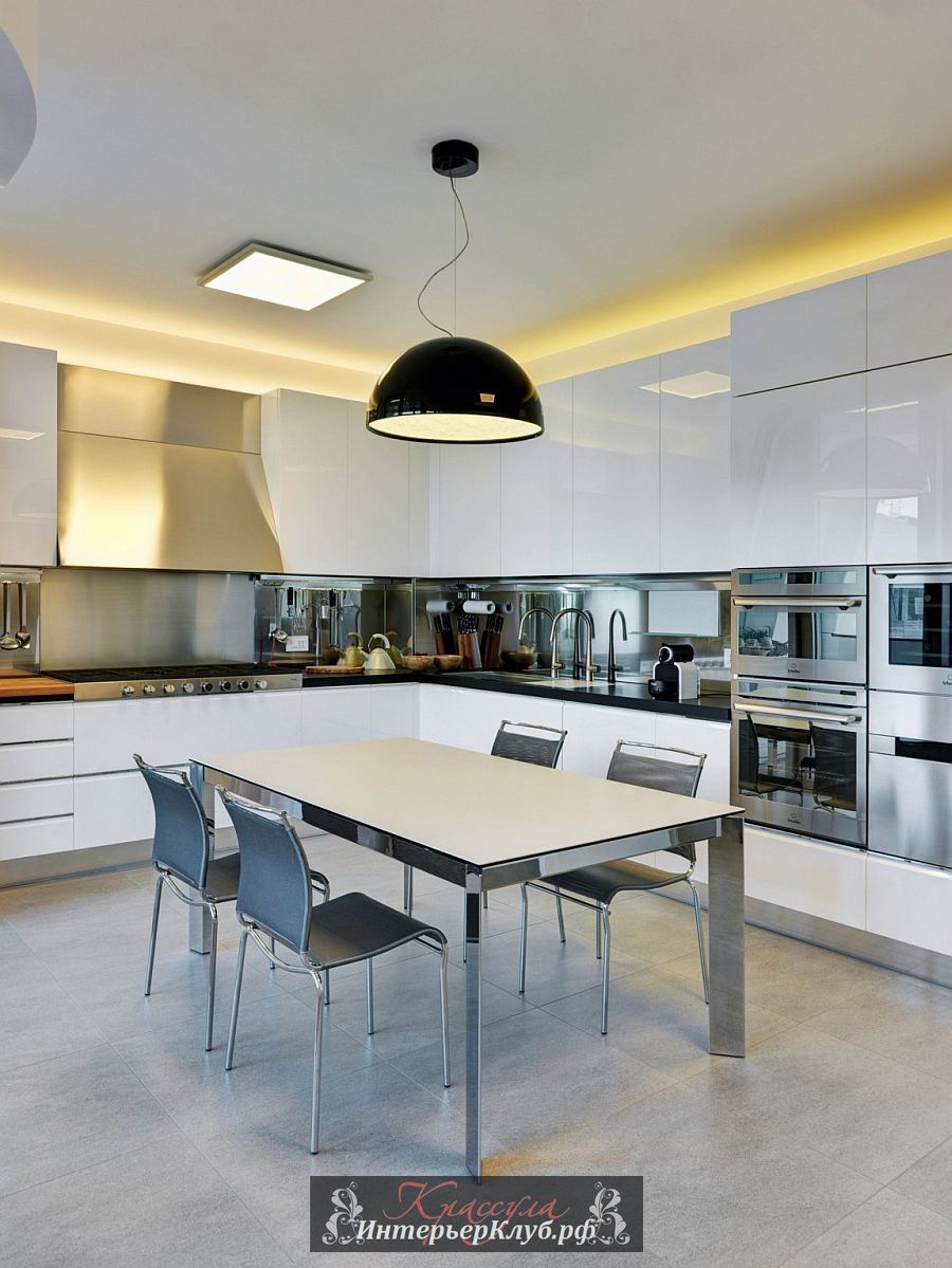 Сферический черный светильник над столом ставит локаничную точку в белом пространстве кухни